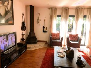 a living room with a television and a fireplace at Spacious home in Cape Towns Blouberg area in Cape Town