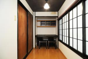 een gang met een bureau in een kamer met ramen bij Samurai tei in Kyoto