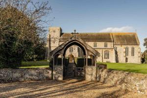 uma velha igreja com um portão em frente em The Chapel em Thornham