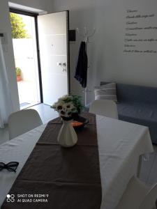 einen Tisch mit einer Vase mit Blumen darauf in der Unterkunft Valevi 111 in Castellana Grotte