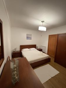 1 dormitorio con cama y mesa de cristal en Casa Da Estrada Velha, en Medonha