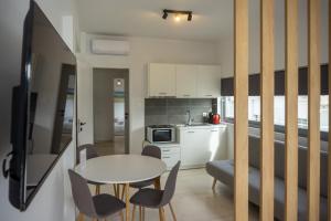een keuken en eetkamer met een tafel en stoelen bij Nest Port View Apartment in Volos