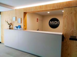 a lobby with a counter with a sign on it at Apartamentos Midi 3000 in Formigal