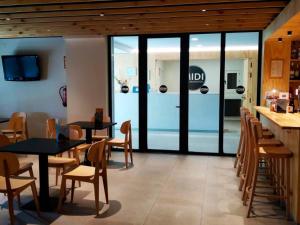 フォルミガルにあるApartamentos Midi 3000のガラスのドア、テーブル、椅子が備わるレストラン