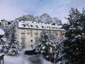 a hotel in the mountains with snow covered trees at Apartamentos Midi 3000 in Formigal
