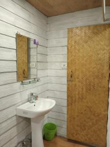 a bathroom with a sink and a mirror at Sawasstika Eco Park Resort in Binnāguri