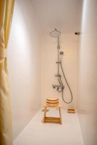 a bathroom with a shower and a wooden stool at RISE BEACH Okumatsushima in Higashimatsushima