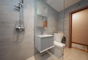 a bathroom with a toilet and a sink and a shower at Apartment Alpi in Peje +16 photos