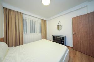 ペヤにあるApartment Alpiの白いベッドと木製キャビネット付きのベッドルーム1室が備わります。