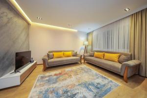 a living room with two couches and a flat screen tv at Apartment Alpi in Peje