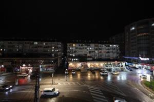 a city at night with cars parked in a parking lot at Apartment Alpi in Peje