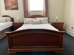 a bedroom with a large wooden bed with two night stands at The Goodlife Guesthouse in Harwich