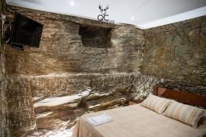 Quinta da Coitada - Alojamento Local في Soutelo do Douro: غرفة نوم بحائط حجري مع سرير