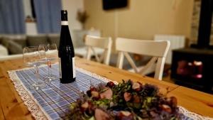 een fles wijn en twee glazen op een tafel bij Chalupa ve Sněžném in Sněžné