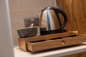 a tea kettle and a cup on a kitchen counter at The Chequers Inn in Knebworth