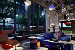 a lobby with a blue couch and chairs and tables at Aloft Tokyo Ginza in Tokyo