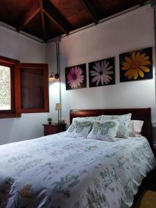 a bedroom with a bed with flowers on the wall at Casa Rural Doña Herminda in La Matanza de Acentejo