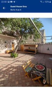 a picture of a courtyard with benches and a building at Guest House Orzu in Khiva