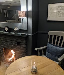 a table and a fireplace in a room at The Keepers Arms in Quenington