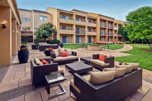 un patio con sofás y mesas y un edificio en Courtyard by Marriott Fairfax Fair Oaks en Fairfax