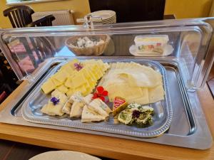 a plastic tray filled with cheese on a table at Hotel Garni Dekorahaus in Bad Schandau +67 photos
