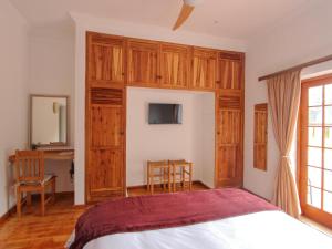 um quarto com uma cama e armários de madeira em Wingrock Guesthouse em Blanco