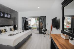1 dormitorio con 1 cama grande y TV en ETK Patong Resort, en Patong Beach