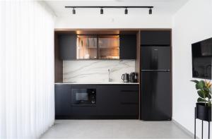 a kitchen with black cabinets and a black refrigerator at premium suite sea side in Eilat