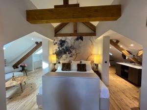 a bedroom with a white bed and wooden floors at Hôtel Restaurant Vaillant proche Europapark Rulantica in Sélestat