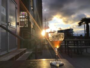 a glass of wine sitting on a table with the sunset at VINTAGE CARAVANE in Les Attaques
