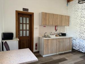 a kitchen with wooden cabinets and a sink and a door at Private One Bedroom Apartment close to Airport in Luqa in Luqa