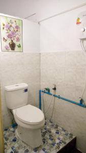 a bathroom with a toilet and a tile floor at Rene's Pasta Bar & Guesthouse in Koh Kong