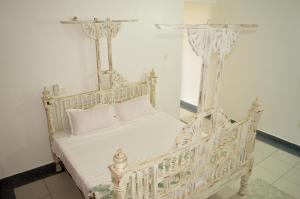 een wit bed met witte lakens en kussens bij Roma Stays - Hibiscus Homes Cozy 3 bedroom near Pride Inn in Mombasa