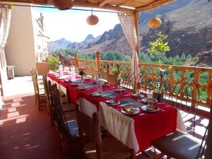 a long table on a balcony with a view at Hotel Atlas Gorge Dades in Boumalne