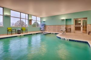 een zwembad met blauw water in een gebouw bij SpringHill Suites by Marriott Coralville in Coralville