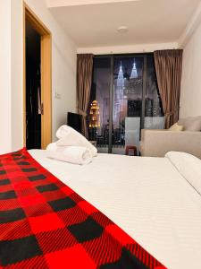 um quarto com uma cama grande e um cobertor vermelho e preto em The Luxe Colony KLCC BY Infinitum em Kuala Lumpur