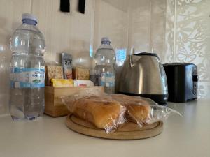 a loaf of bread on a cutting board next to bottles of water at Private One Bedroom Apartment close to Airport in Luqa in Luqa