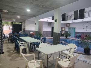 ein Restaurant mit Tischen und Stühlen neben einem Pool in der Unterkunft Proyecto MOONLIGHT in Villavieja