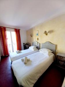 a hotel room with two beds and a window at Hotel Restaurant Le Costabonne in Prats-de-Mollo-la-Preste