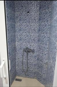 y baño con ducha de azulejos azules. en Tangier city center, en Tánger