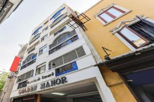 a building with a sign for a grocery store at OYO Flagship Golden Manor in Chennai