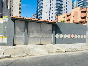 ein Gebäude an der Seite einer Straße mit hohen Gebäuden in der Unterkunft Seu Cantinho na Vila Tupi 3 Dormitórios in Praia Grande