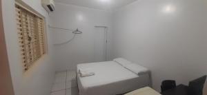 a white bathroom with a toilet and a window at Hotel Arara Azul in Barra do Garças +4 photos