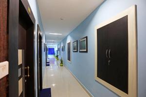 a hallway with blue walls and a black door at Sai Swastik in Bhubaneshwar