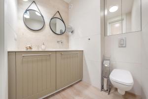 une salle de bain avec toilettes et miroir dans l'établissement Kubacza, Sun & Snow, à Sopot