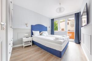 une chambre avec un lit bleu et une fenêtre dans l'établissement Kubacza, Sun & Snow, à Sopot