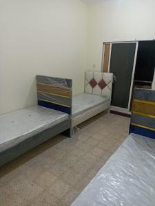 2 lits sont installés dans une pièce avec une baie vitrée dans l'établissement NuZee Hostel for Girls only, à Dubaï