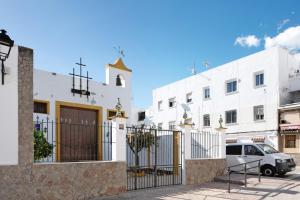Un edificio blanco con una puerta y una camioneta estacionada enfrente. en Ula Home, en Barbate