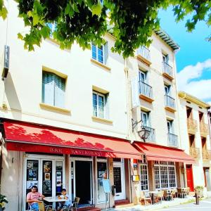 dos personas sentadas en una mesa fuera de un edificio en Hotel Restaurant Le Costabonne, en Prats-de-Mollo-la-Preste