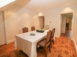 a dining room with a white table and chairs at The House at The Sitwell Arms in Sheffield